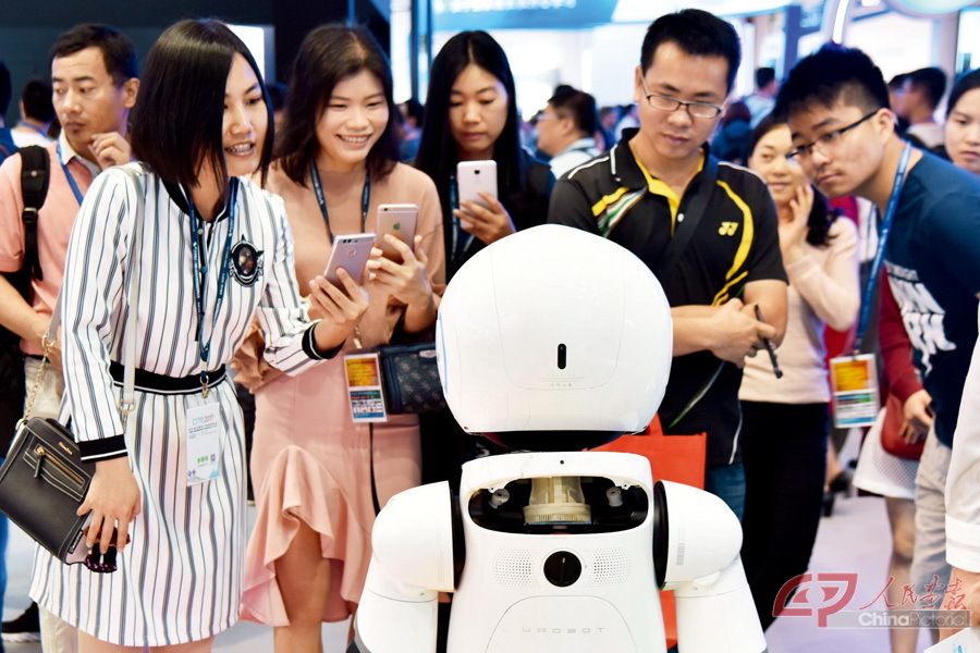 April 9, 2017: Spectators take a picture of an AI robot at the Fifth China Information Technology Expo in Shenzhen. CFP