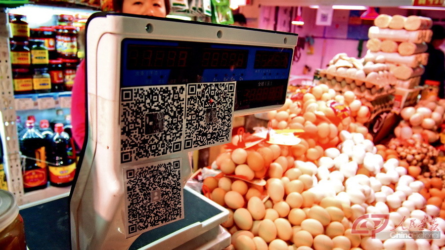 March 1, 2017: Merchants in a farmers' market in Jinan City, capital of Shandong Province, accept payment through scanning a QR code. CFP